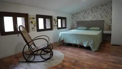a bedroom with a bed and a chair in it at Magnifique Mas avec Piscine - La Bergerie du Razès in Alet-les-Bains