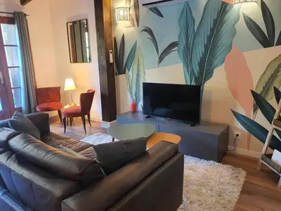 a living room with a couch and a tv at Magnifique Mas avec Piscine - La Bergerie du Razès in Alet-les-Bains