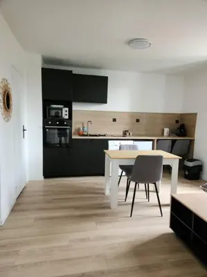 a kitchen with a white table and chairs in a room at Le Maillot V in Castres