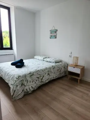a bedroom with a bed and a wooden floor at Le Maillot V in Castres