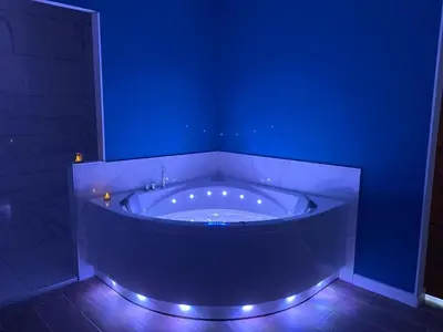a blue bathroom with a tub with lights in it at Bulles de bonheur - Carcassonne in Carcassonne