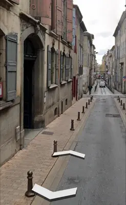 an empty street with a white arrow on the road at Bulles de bonheur - Carcassonne in Carcassonne