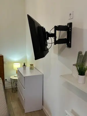 a room with a television on a wall with a cabinet at Bulles de bonheur - Carcassonne in Carcassonne