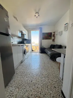 a kitchen and living room with a couch and a table at T2 moderne à 2 min de la plage in Port-la-Nouvelle