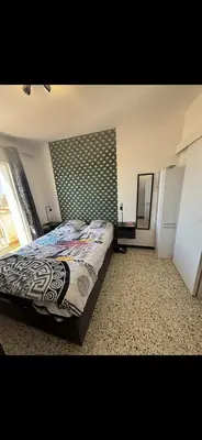 a bedroom with a bed and a large window at T2 moderne à 2 min de la plage in Port-la-Nouvelle
