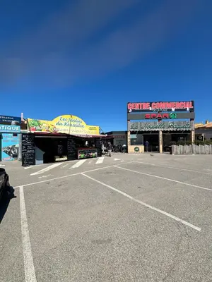 an empty parking lot in front of a shopping center at T2 moderne à 2 min de la plage in Port-la-Nouvelle