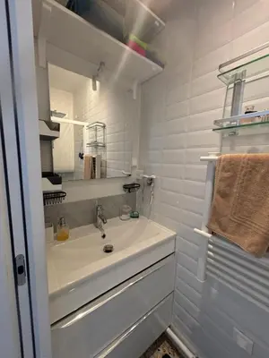 a white bathroom with a sink and a mirror at T2 moderne à 2 min de la plage in Port-la-Nouvelle