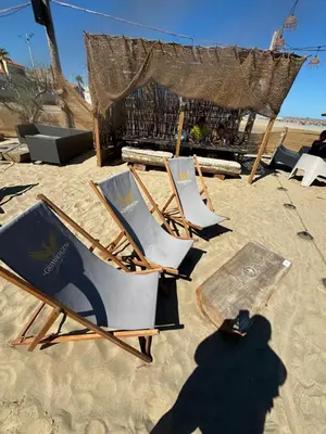 two lawn chairs and a table on a beach at T2 moderne à 2 min de la plage in Port-la-Nouvelle