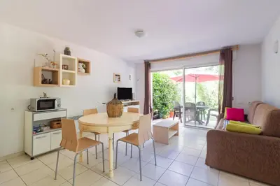 a kitchen and living room with a table and a couch at Douceur de Jouarres - Avec piscine in Azille