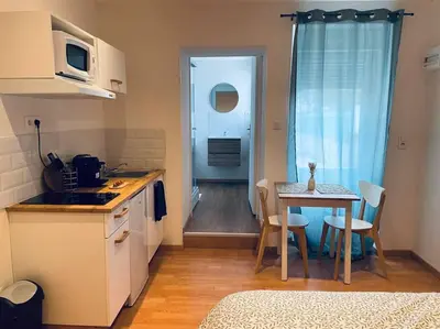 a small kitchen with a table and a dining room at Studio Charles de Gaulle II in Castres