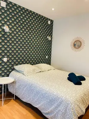 a bedroom with a bed and a table in it at Studio Charles de Gaulle II in Castres