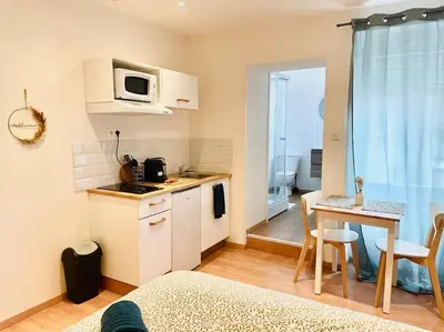a small kitchen with a table and a microwave at Studio Charles de Gaulle II in Castres
