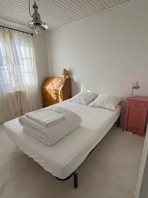 a bedroom with a large bed with white sheets at Maison 300 m de la plage avec un bel extérieur in Gruissan