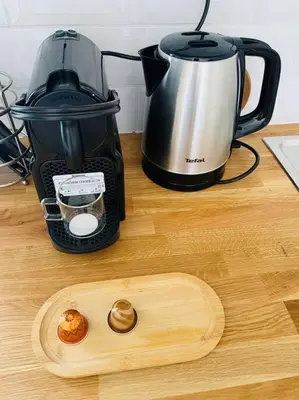 a wooden cutting board next to a coffee maker on a counter at Studio Charles De Gaulle IV in Castres