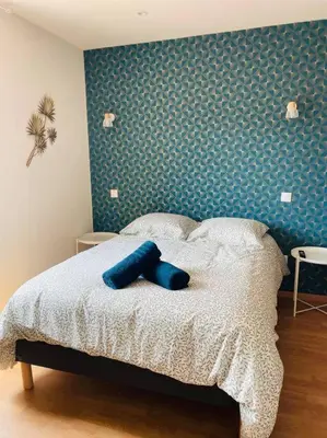a bedroom with a bed with a blue wall at Studio Charles De Gaulle IV in Castres