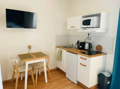 a small kitchen with a table and a microwave at Studio Charles De Gaulle IV in Castres