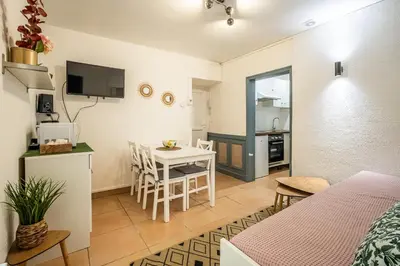 a room with a bed and a kitchen with a table at Le Cocon Urbain in Narbonne