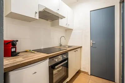 a small kitchen with a sink and a stove at Le Cocon Urbain in Narbonne