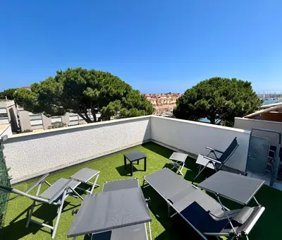 a patio with chairs and tables on a roof at L'appart B42 in Gruissan