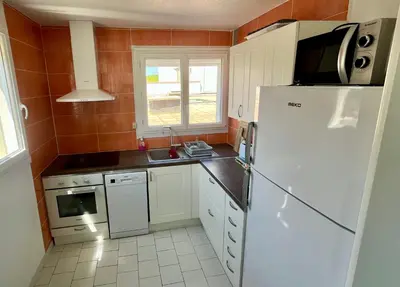 a kitchen with a white refrigerator and a sink at L'appart B42 in Gruissan