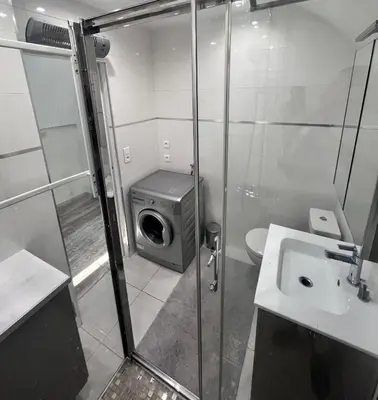 a bathroom with a washing machine and a sink at L'appart B42 in Gruissan