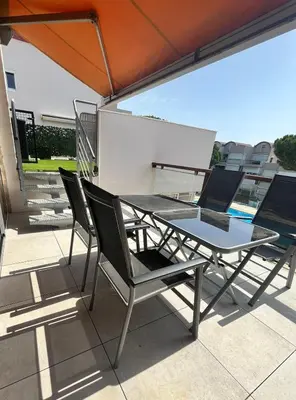 a table and chairs on a balcony with an umbrella at L'appart B42 in Gruissan