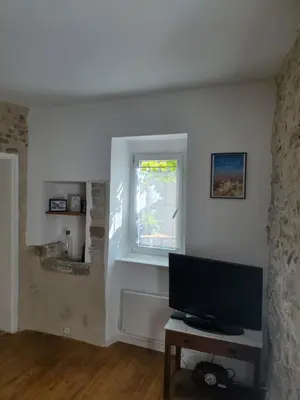 a living room with a tv and a window at Charmante Petite Maison Audoise in Trausse