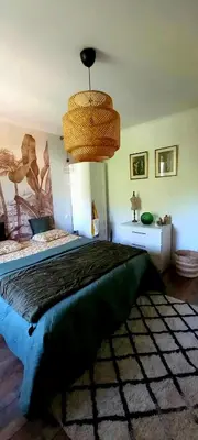 a bedroom with a bed and a chandelier at La maison d'Aude in Quillan