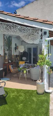 a patio with green grass and a table and chairs at La maison d'Aude in Quillan