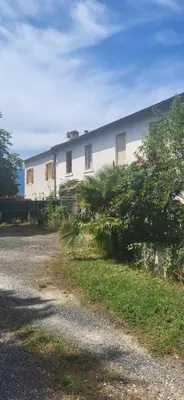 a white building with windows on the side of a road at La maison d'Aude in Quillan