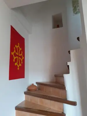 a staircase with a red flag on the wall at La Petite Tour de Puivert in Puivert