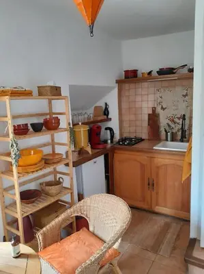 a kitchen with wooden cabinets and a counter top at La Petite Tour de Puivert in Puivert