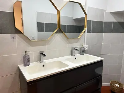 a bathroom with a white sink and a mirror at T2 climatisé - Près des plages in Narbonne