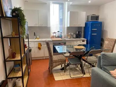 a kitchen with a glass table and chairs in a room at T2 climatisé - Près des plages in Narbonne
