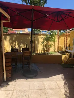 a red umbrella sitting on top of a table at Grand T2 climatisé avec jardin et spa in Narbonne
