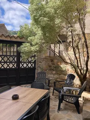 a patio with a table and chairs and a tree at Maison 2 chambres avec cour intérieure in Alet-les-Bains