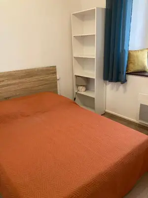 a bedroom with a bed with an orange bedspread at Maison 2 chambres avec cour intérieure in Alet-les-Bains