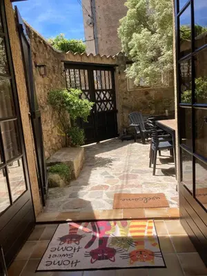 an open door to a patio with a table and chairs at Maison 2 chambres avec cour intérieure in Alet-les-Bains