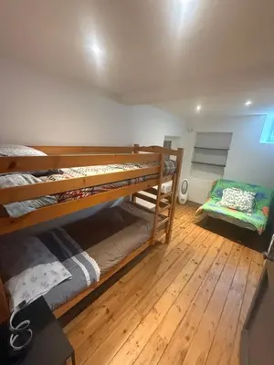 two bunk beds in a room with wooden floors at Charmante maison de village in Bram