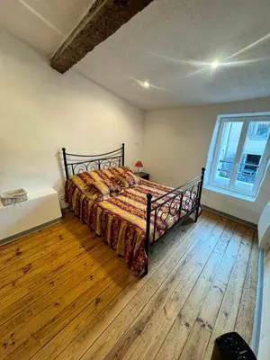 a bedroom with a bed and a large window at Charmante maison de village in Bram