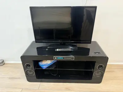 a tv sitting on top of a black entertainment center at Charmante maison de village in Bram