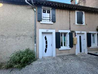a house with a white door and a window at Charmante maison de village in Bram