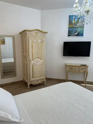 a bedroom with a bed and a dresser and a tv at Studio Cosy du Cloitre in Narbonne