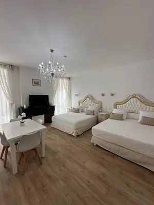 a bedroom with two beds and a table and a piano at Studio familial du Cloitre in Narbonne