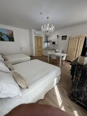a bedroom with two beds and a dining room at Studio familial du Cloitre in Narbonne