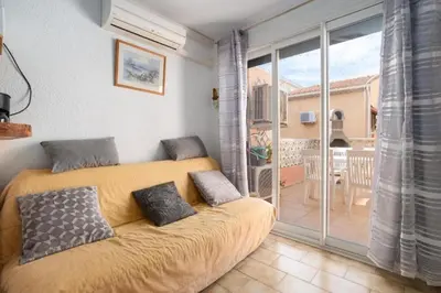a bedroom with a bed and a balcony with a patio at Le Mieukerien - Réserve africaine 15 mn - Plage 200 m in Port-la-Nouvelle