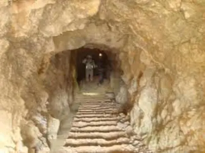 a tunnel in a mountain with a person walking through it at Le Mieukerien - Réserve africaine 15 mn - Plage 200 m in Port-la-Nouvelle