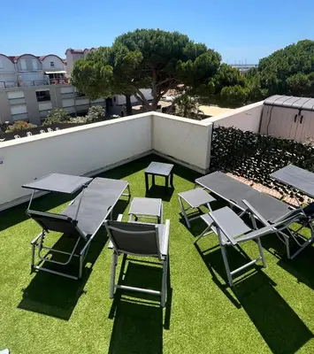 a group of picnic tables and chairs on the grass at L'appart D79 in Gruissan
