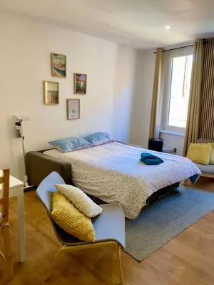a bedroom with a bed with a blue comforter at Chez Isa et Thomas in Narbonne