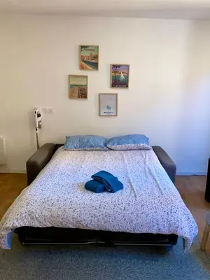a bedroom with a bed with a blue hat on it at Chez Isa et Thomas in Narbonne